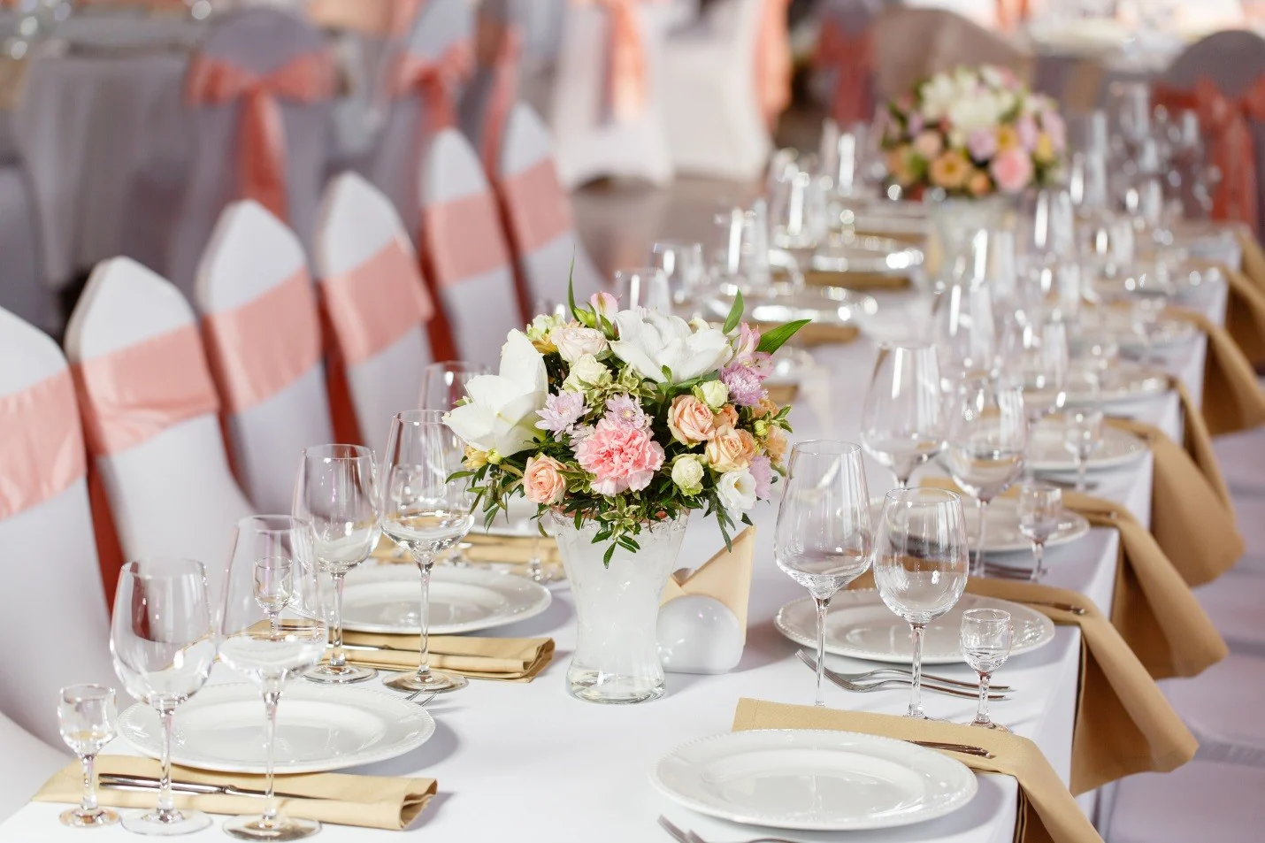 white tablecloths with white chair covers and pink chair sashes